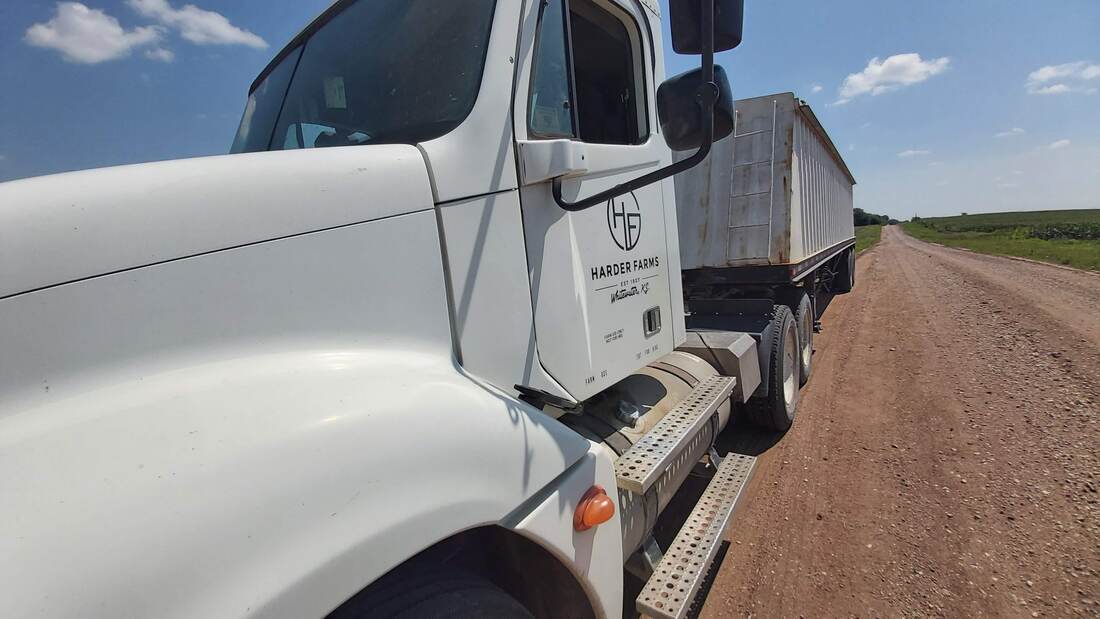 A Harder Farms truck beside the field